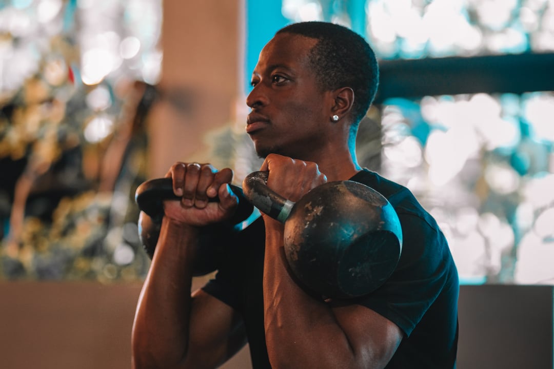 A kettlebell front-rack squat in a bright, uncrowded session at Rumble