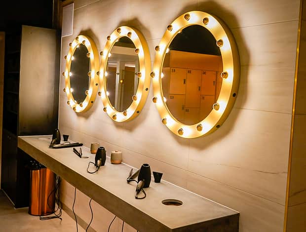 Changing room with lit vanity mirrors at Rumble Dalston